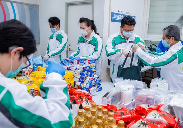 Volunteers from the Hang Lung As One Volunteer Team help package the health and food kits