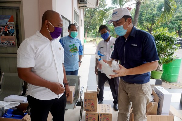 Rony Hutagalung from Ecolab Food and Beverage division, handing in-kind donations to Drs. Santoso, MA, Secretary of Gunung Putri District Government Office in West Java, Indonesia
