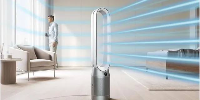 Dyson Air Purifier purifying the living room with a man standing by rthe window enjoying the freshness from the air purifier