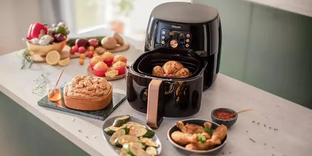 Air fryer on an island with various foods that can use the air fryer to cook
